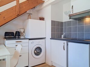 A compact kitchen with a washing machine, a coffee maker, and a toaster on the counter. - Les 3 voiles by Interhome (Maubuisson)