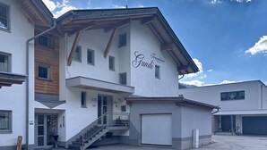 Un edificio moderno con un'insegna che recita 'Ferienhaus Gundi' e una scala che conduce all'ingresso.