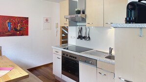 Una cucina moderna con forno integrato, macchina da caffè e lavello in acciaio inossidabile.