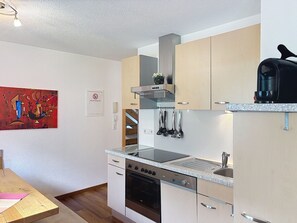 A modern kitchen with a built-in oven, a coffee machine, and a stainless steel sink. - Ferienhaus Gundi by Interhome (Pettneu am Arlberg)