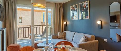 Una sala de estar moderna con comedor, sofá y balcón con vistas.