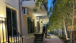Un edificio con un camino de ladrillo, una escalera y un balcón.