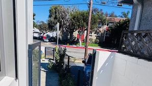 A narrow alleyway with a concrete path, bordered by white walls and a metal fence. - Award-Winning Eco Retreat with Fresh Air - certified Passive House (Los Angeles)