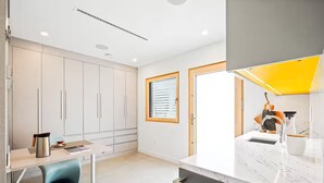 A modern kitchen with white cabinets, a marble countertop, and a built-in oven. - Award-Winning Eco Retreat with Fresh Air - certified Passive House (Los Angeles)