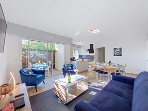 Ein modernes Wohnzimmer mit einer Couch, einem Couchtisch und einem Essbereich mit Stühlen.