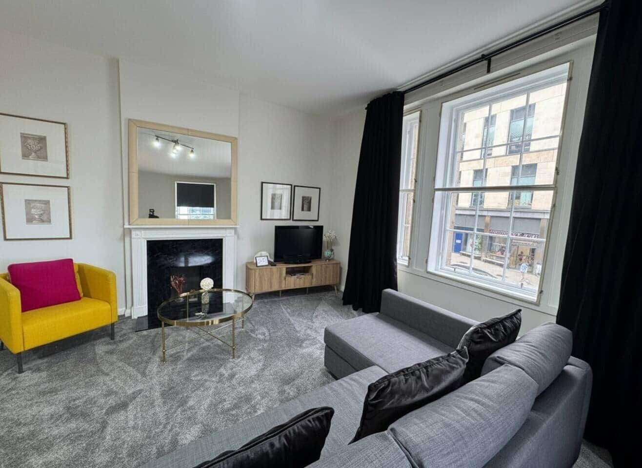 A living room with a fireplace, a television, a sofa, and a coffee table.