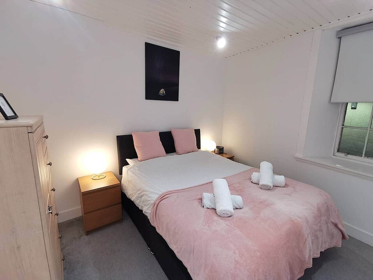 Una camera da letto con un letto, un comodino e una finestra.
