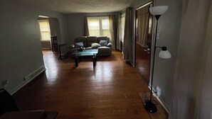 Un salon spacieux comprenant un ensemble de canapés, une table basse et un lampadaire.