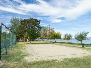 A volleyball court with a net, surrounded by trees and a body of water. - Apartment Silver by Interhome (Siofok)