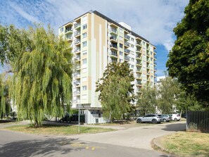 A multi-story residential building with balconies, a parking area, and surrounding greenery. - Apartment Silver by Interhome (Siofok)
