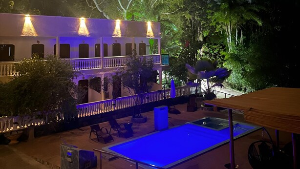 A building with a pool area, outdoor seating, and a well-lit facade.