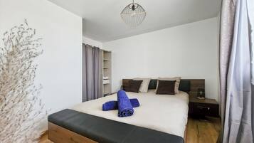 A hotel room with a bed, a nightstand, a lamp, and a ceiling light fixture.