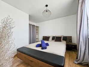 A hotel room with a bed, a nightstand, a lamp, and a ceiling light fixture. - Crystal House - Family Home, Private Garden, 15 Minutes from Disneyland (Villiers-sur-Morin)