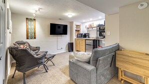 A compact living space with a sofa, a television, a kitchen area, and a small dining table. - Work, Play & Explore w/ Ease! Dtwn Meridian Apt (Meridian)