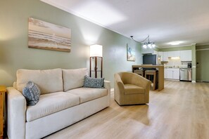 A living room with a sofa, armchair, and a dining area with a table and chairs. - 1 Mi to Beach! HHI Extended Escape w/ Balcony (Hilton Head Island)