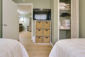 A bedroom with two beds, a television on a stand, and a wardrobe with storage bins. - 1 Mi to Beach! HHI Extended Escape w/ Balcony (Hilton Head Island)