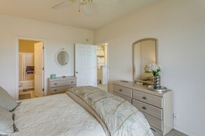 A bedroom with a bed, dresser, mirror, and a door leading to another room. - Golf Resort Stay in Sunset Beach: Pool, Balcony (Sunset Beach)