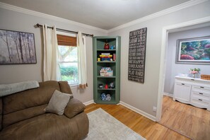 A living room with a brown sofa, a green bookshelf, a white cabinet, and a motivational quote on the wall. - Aiken Equestrian Dog Friendly  Bruce's Field (Aiken)