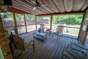 An outdoor patio with wooden flooring, metal chairs, a glass table, and a ceiling fan. - Aiken Equestrian Dog Friendly  Bruce's Field (Aiken)