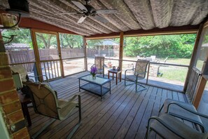 An outdoor patio with wooden flooring, metal chairs, a table, and a ceiling fan. - Aiken Equestrian | Dog Friendly |Bruce's Field (Aiken)