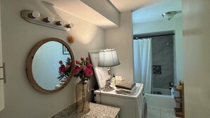 Casa de banho com lavatório, espelho, toucador e zona de duche.