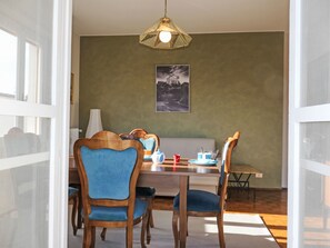 A dining area with a table, chairs, and a hanging light fixture. - Casa Mandarino by Interhome (Bordighera)