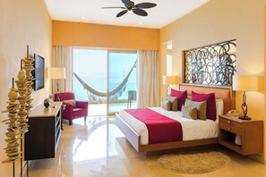 Ein Hotelzimmer mit Bett, Schreibtisch, Stuhl, Hängematte und Meerblick.