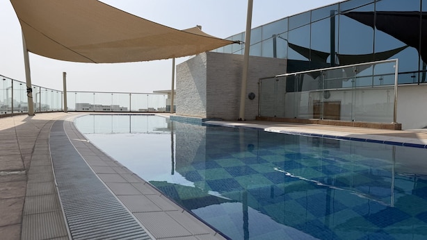 A rooftop swimming pool with a clear view of the cityscape in the background. - The Hive - Cozy 2BR Apartment with Rooftop Pool, Al Khuwair Muscat (Muscat)