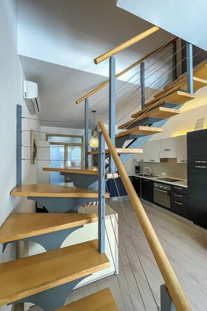 A modern kitchen with a wooden staircase. - Vacation home Volme by Interhome (Pula/Banjole)
