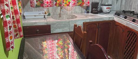 Una cocina con microondas, estufa y cafetera sobre la encimera.