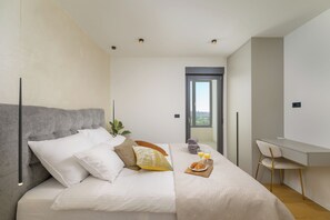A modern bedroom with a bed, bedside table, and a desk with a chair. - Villa Monte Serpo (Istria - Pula) (Pula)