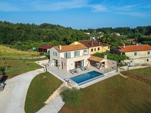 A villa with a swimming pool, outdoor seating, and a view of the surrounding landscape. - Villa Pepo (Istria - Pićan) (Pićan)