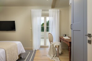 Ein Schlafzimmer mit einem Bett, einem Schreibtisch mit Stuhl, einem Fernseher und einer Schiebetür.