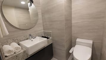 Un bagno moderno con lavandino, specchio e water.