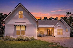 A two-story house with a front porch, a garage, and a small garden area.