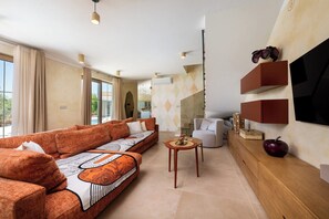 A modern living room with a sofa, a coffee table, and a TV mounted on the wall. - Vila Da Ella by Istrabook (Krnica)