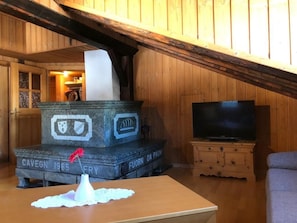 Une pièce comprenant un monument en pierre, un téléviseur et un coin salon confortable.