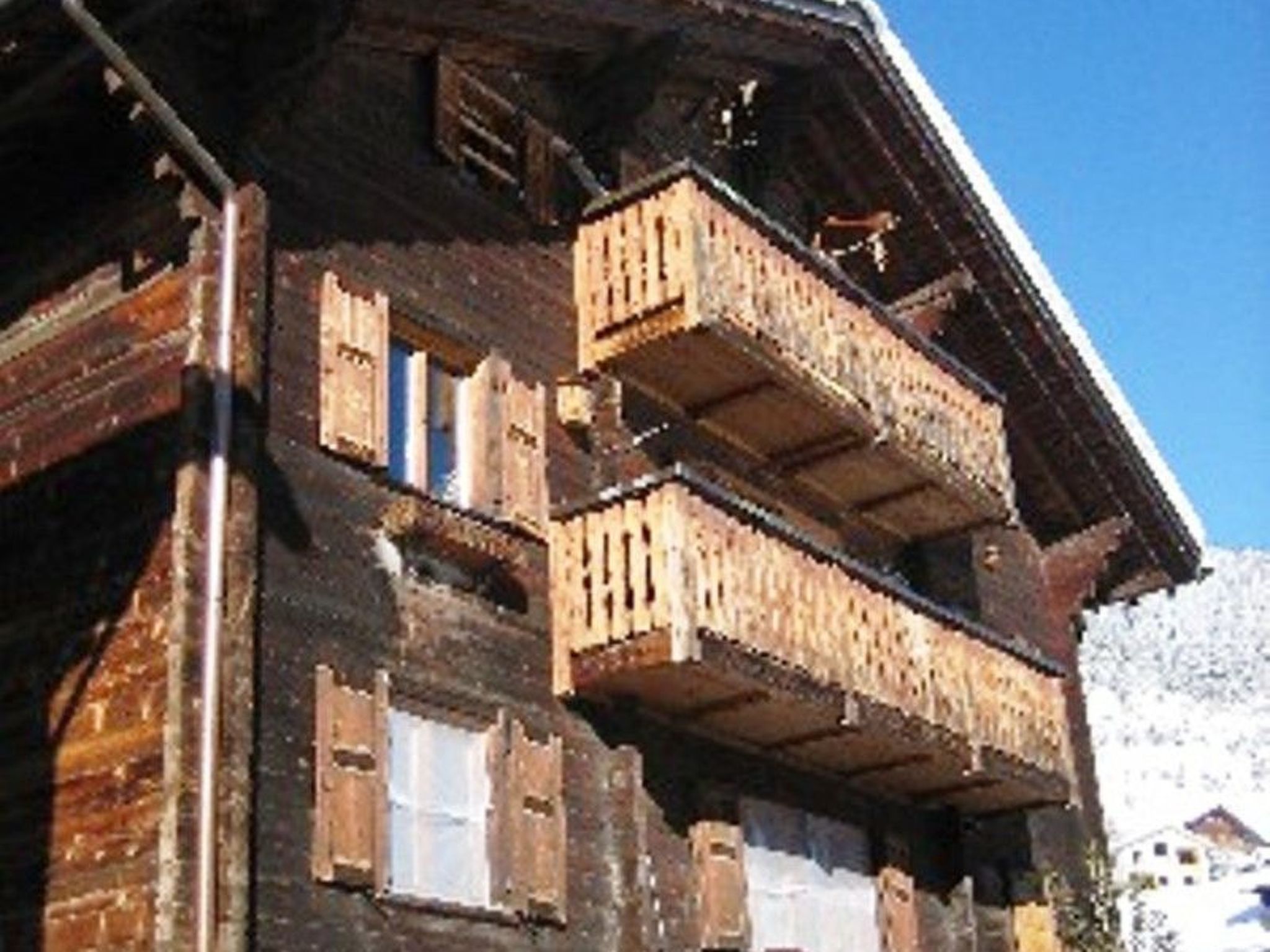 Un chalet en bois doté de nombreux balcons et fenêtres.