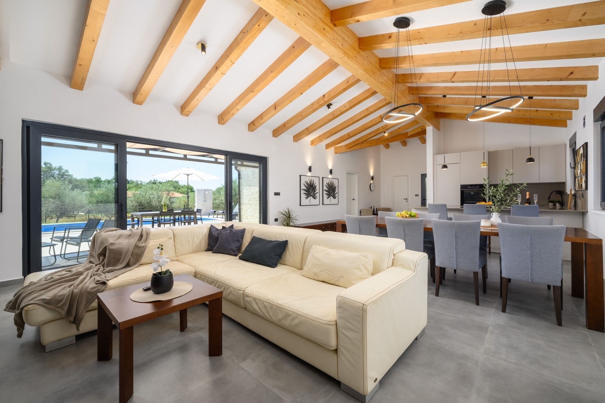 A modern living room with a sofa, coffee table, and dining area with chairs.