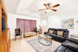 A living room with a sofa, chairs, a coffee table, a TV, and a ceiling fan. - Huge Backyard • Community Pool • Near Arena (Pharr)