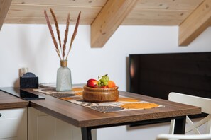 A wooden table with a fruit bowl, a vase with dried plants, and a smartphone on it. - Wooden wellness home with sauna in the heart of Gorski Kotar (Fužine)