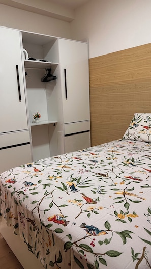A bedroom with a bed, a wardrobe, and a wooden headboard. - Apartment near the airport with a combined balcony, air conditioning, and a hammock. (Aracaju)