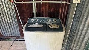 A washing machine with a control panel, set against a corrugated metal wall. - Grenn House (Sámara)