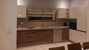 A modern kitchen with a dishwasher, oven, and a window above the sink. - Exceptional villa with a pool (Essaouira)