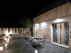 Ein Patio mit Steinsitzgelegenheit und einer Schiebeglasdoor.