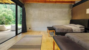 Ein modernes Schlafzimmer mit großem Fenster, einem Bett, einer Bank und einem Teppich.