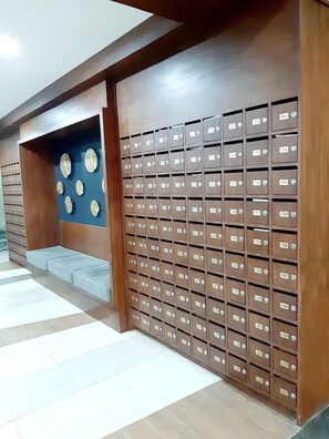 A row of brown mailboxes with numbers on them, arranged in a wall. - 5 mins to Mactan Airport quite stay with pool, gym and balcony. (Lapu-Lapu)