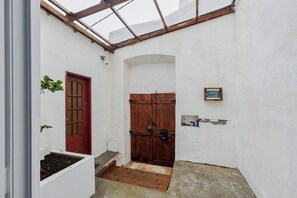 A narrow corridor with a wooden door, a small window, and a white wall. - Palmela Oasis Apartment II, By Home Match (Palmela)