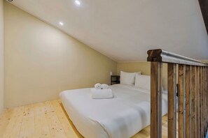 A bedroom with a wooden floor, a bed with white linens, a nightstand, and a ceiling light. - Palmela Oasis Apartment II, By Home Match (Palmela)