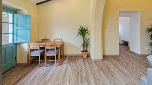 A dining area with a wooden table and chairs, a potted plant, and a blue door. - Palmela Oasis Apartment II, By Home Match (Palmela)